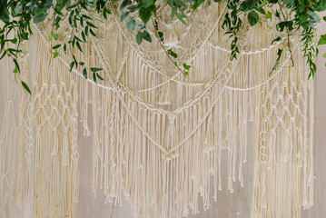 Wedding arch is decorated leaves eucalyptus greenery and garland with lights in tent. Banquet hall...