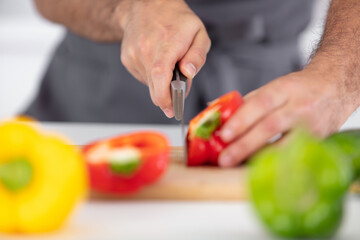 closeup of man hands cutting vegetables on wooden table