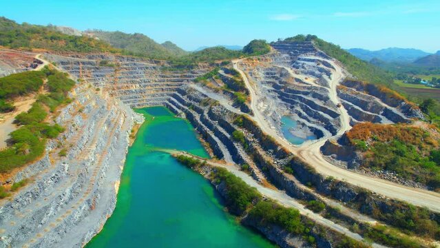 Drone flying over a quarry in the tropical, large commercial industry for infrastructure. pollution problems from dust respiratory tract and environmental problems concept. Aerial view footage. 4K
