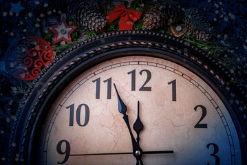Fototapeta na wymiar The old clock shows five minutes to midnight. On the background of decorations. New Year - concept.