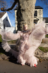 fashion portrait of non-binary person wearing pink tulle dress in suburbia