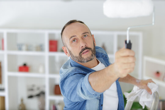 painter painting the ceiling in construction concept