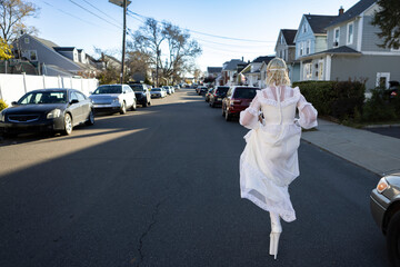 fashion portrait of non-binary person wearing white dress in suburbia