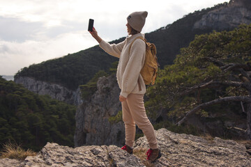 A woman traveler takes a photo of nature with her smartphone. Photo of a beautiful view of nature.
