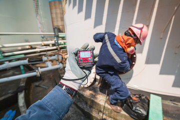Worker hand holding gas detector inspection safety gas testing at front male in to manhole tank