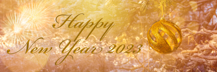 Happy New Year 2023! Blurred background of Christmas tree decorated with big golden ball. Bokeh....