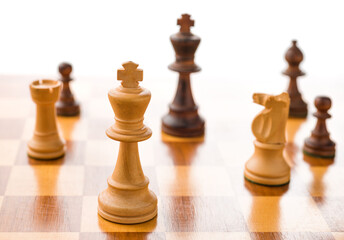 Chess pieces on a chessboard with white background