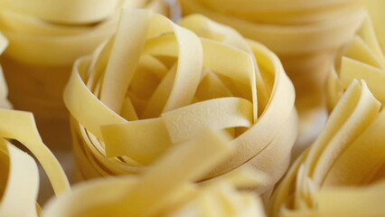 Raw homemade pasta tagliatelle. Fresh homemade egg pasta . Fettuccine pasta raw. Nest of yellow tagliatelle. Rotation 4K