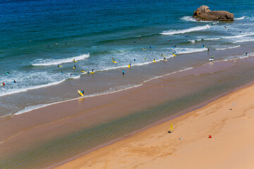 View of surfers on sandy beach