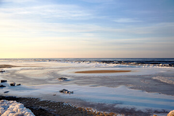 Winter view on the icy sea coast and beautiful calm sky, selective focus