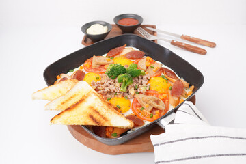 Fast food breakfast, fried eggs in pan and vegetables