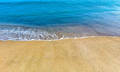 Beach sand blue water huge surfer waves Puerto Escondido Mexico.