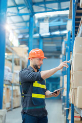 Warehouse workers in helmets checking goods and supplies on shelves with goods background in warehouse worker packing in a large warehouse in a large warehouse. Logistics industry concept.