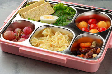 Lunch box with ready food on gray background