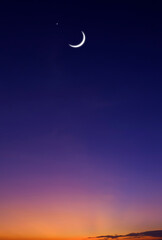 Obraz na płótnie Canvas Crescent moon and star on colorful dusk sky in vertical frame, Beautiful Twilight background with free space for text Ramadan, Eid Al Adha, Mubarak, Eid Al Fitr, Muharram