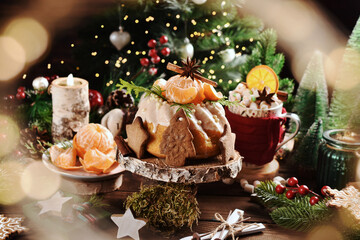 Christmas table with mandarin flavored ring cake decorated with fresh fruits