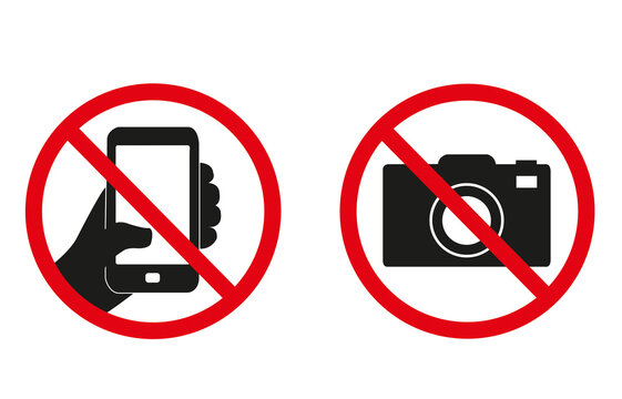 Fotografía y señal de prohibición de uso de teléfonos inteligentes sobre un fondo blanco liso y aislado. Vista de frente y de cerca