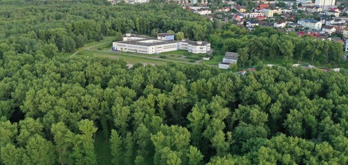 Minsk, Belarus - August 17, 2022: School for teaching deaf and dumb people in the Sevastopol park in Minsk. A building surrounded by trees and a flowering park.