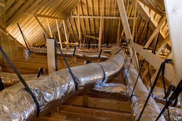 In newly built home under construction ventilation pipes are silver insulation material on ceiling...