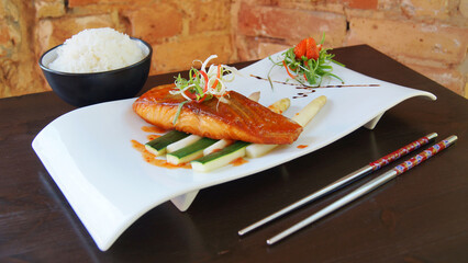 Asian combo plate with salmon served with rice or noddles. Dish with cooked salmon in a restaurant in Tokyo.
