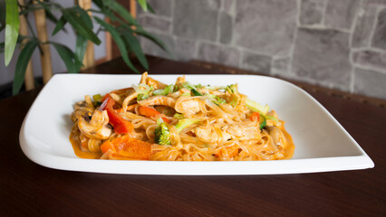 Asian combo plate with chicken and vegetables served with noddles.