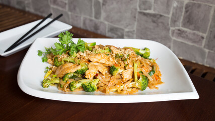 Asian combo plate with chicken and vegetables served with noddles.