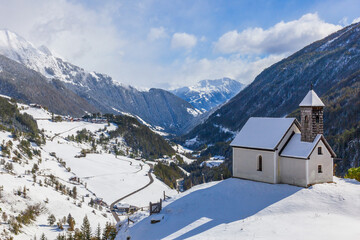 Church on a hill in a snowy alp valley