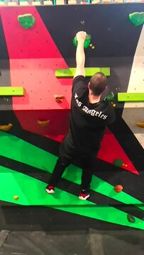 People bouldering on a climbing problem in a ninja warrior type experience