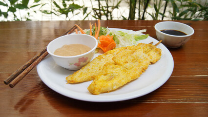 Skewers with battered chicken and peanut sauce. Traditional Asian recipe.