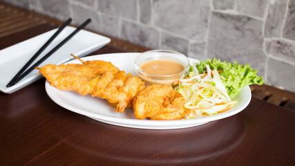Skewers with battered chicken and peanut sauce. Traditional Asian recipe.
