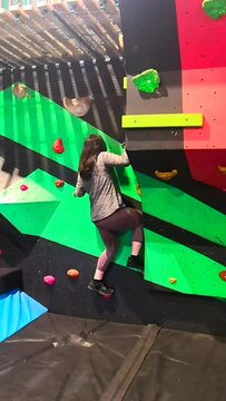 People bouldering on a climbing problem in a ninja warrior type experience