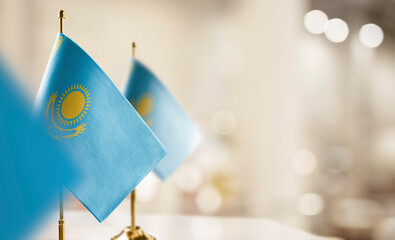 Small flags of the Kazakhstan on an abstract blurry background