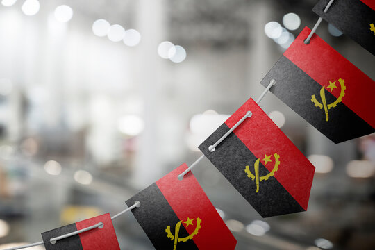 A garland of Angola national flags on an abstract blurred background