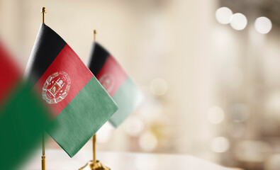 Small flags of the Afghanistan on an abstract blurry background