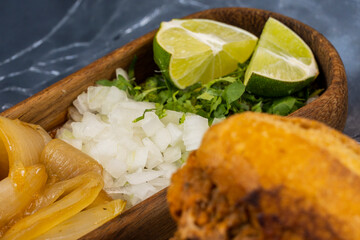 torta ahogada consome y birria, dish with onion, sweet onion and chile, wooden plates beef soap