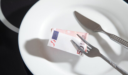 Plate with a euro money, fork and knife.