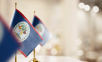 Small flags of the Belize on an abstract blurry background