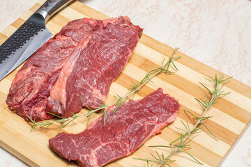 
meat steak on wooden board on white quartz