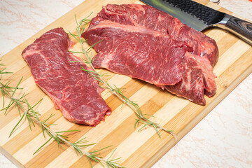 
meat steak on wooden board on white quartz