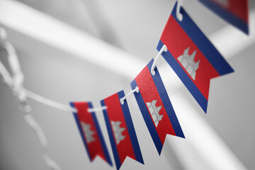 A garland of Cambodia national flags on an abstract blurred background