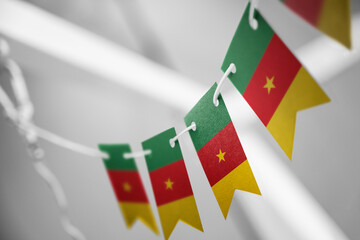 A garland of Cameroon national flags on an abstract blurred background
