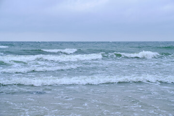 Surf wave with foam splashes on sea.