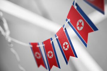 A garland of North Korea national flags on an abstract blurred background