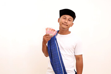 Happy asian man while holding a indonesian money. Isolated on white. Ramadan concept