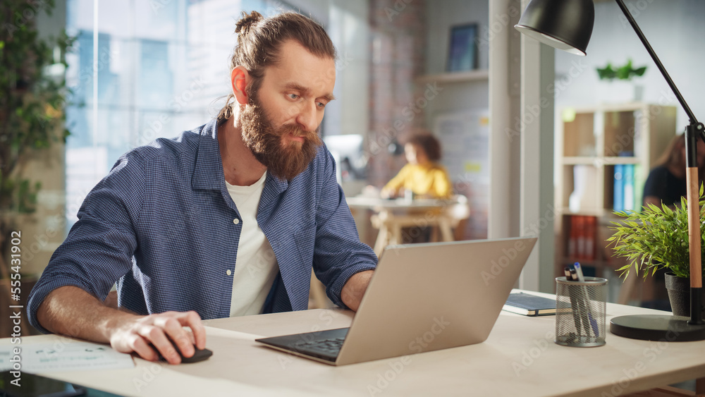Poster close up portrait of a handsome long-haired bearded manager sitting at a desk in creative office. st
