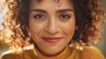 Close Up Portrait of a Young Middle Eastern Woman with Short Curly Hair, Looking for Camera, Wearing a Yellow Sweater. Beautiful Diverse Multiethnic Female Wearing Yellow Smiling and Being Happy. - Powered by Adobe