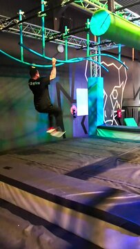 People bouldering on a climbing problem in a ninja warrior type experience