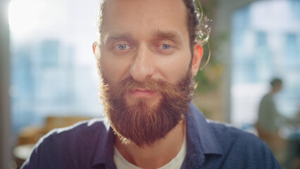 Portrait of a Handsome Man in Creative Agency. Young Stylish Manager with Long Hair and a Beard Looking at Camera. Successful Manager Working in Modern Company.