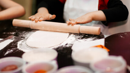 Fototapeta na wymiar close up.a professional chef teaches a little boy to roll out the dough.