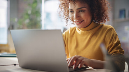 Middle Eastern Female Sitting in Creative Agency, Working on Implementing Modern Business Strategy for a Client. Successful Specialist Writing Corporate Project Plans on Laptop Computer.